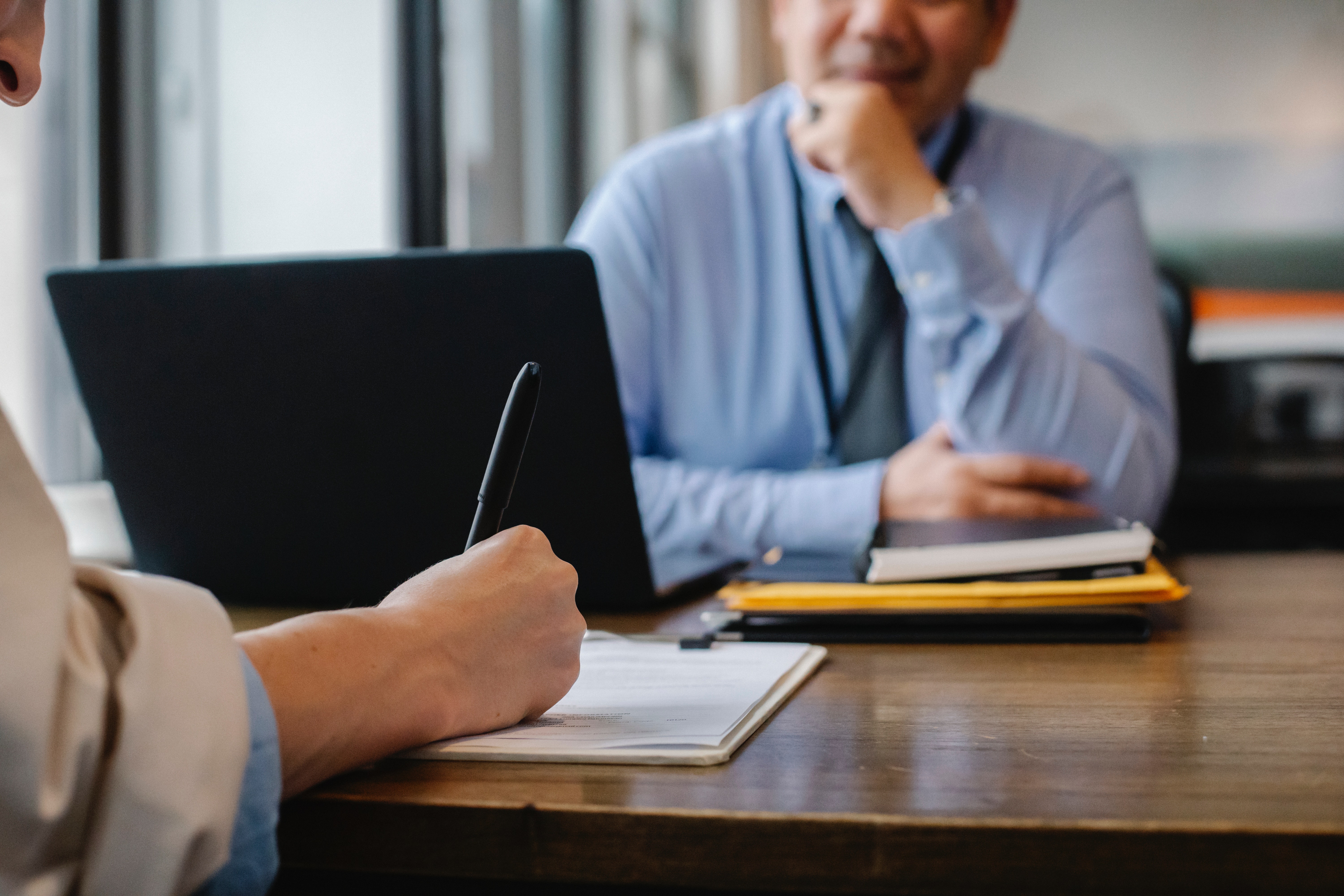 Woman filling job application form in office with boss