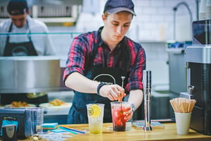 Bartender holding drinking glass while working.