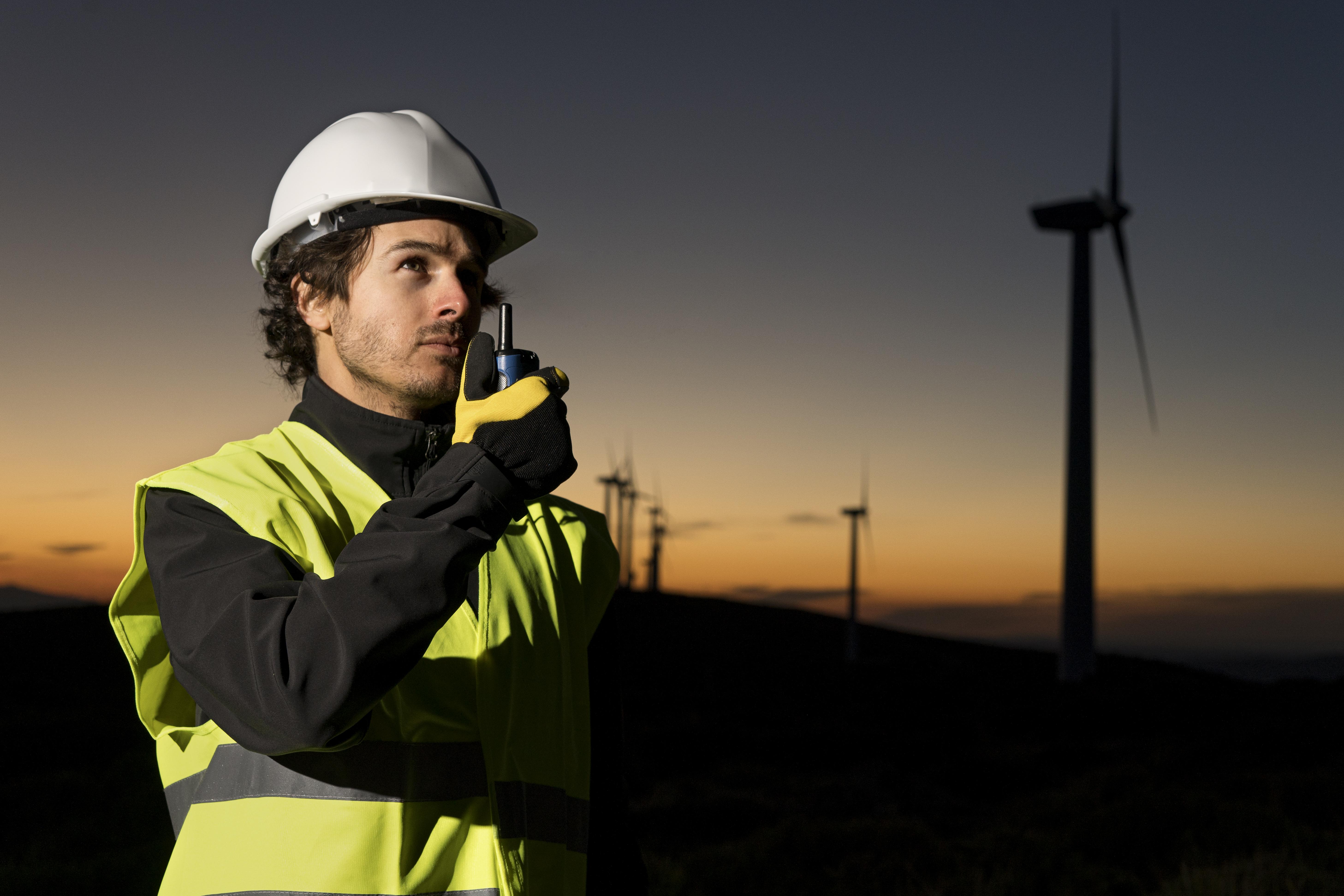 Man standing on wind mill farm